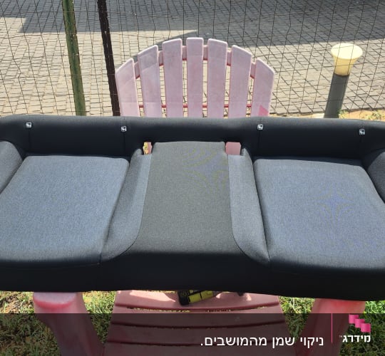 מושב רכב מונח על כיסא ורוד בחוץ